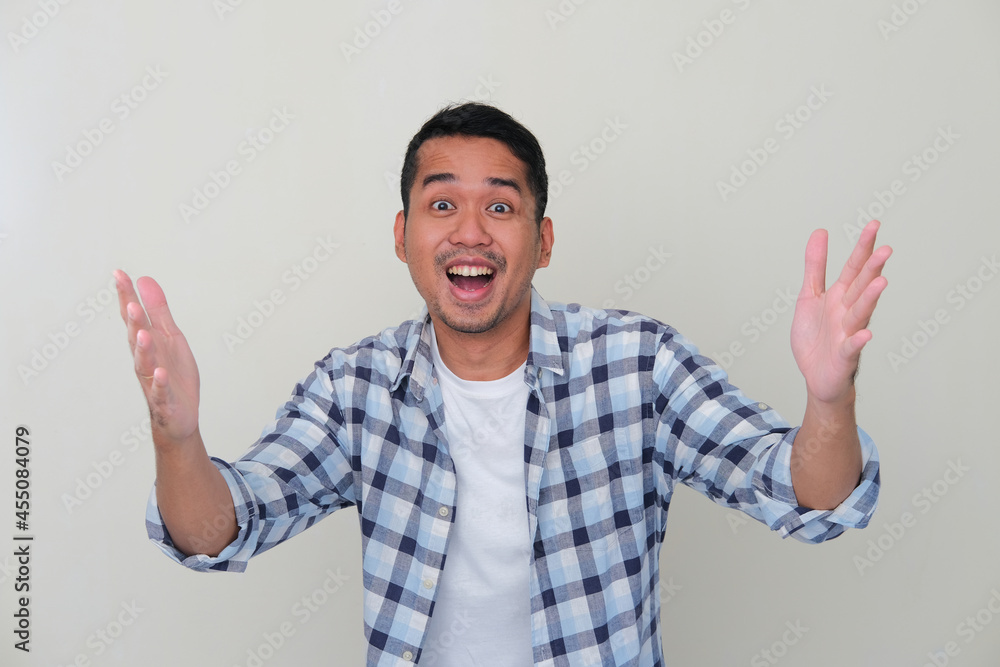 Young Asian man showing excited face expression when trying to get something Young Asian man showing excited face expression when trying to get something