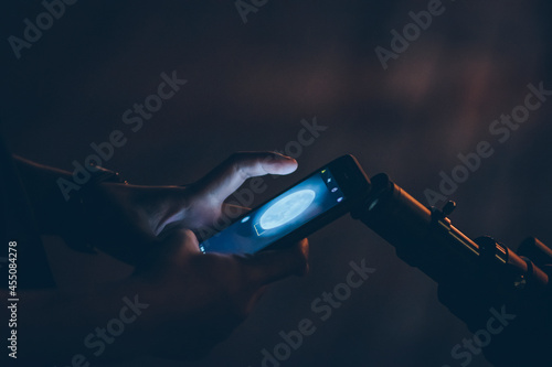 Mobile phone photographing the moon from the telescopic viewfinder at night.