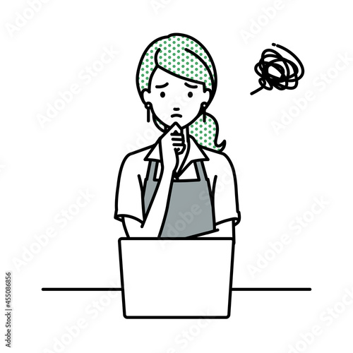 デスクで座ってPCを開いて困っているカフェ店員の女性
