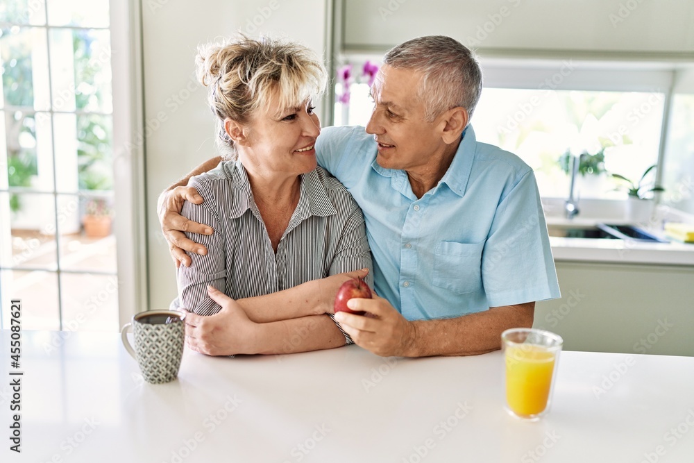 Obraz premium Senior caucasian couple smiling happy having breakfast at the kitchen.