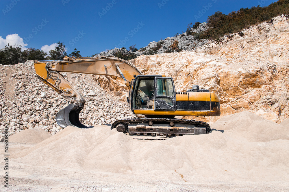Excavator hydraulic industrial machines working in quarry preparing stone for construction industry. Excavator hydraulic industrial machines working in quarry preparing stone for construction industry.