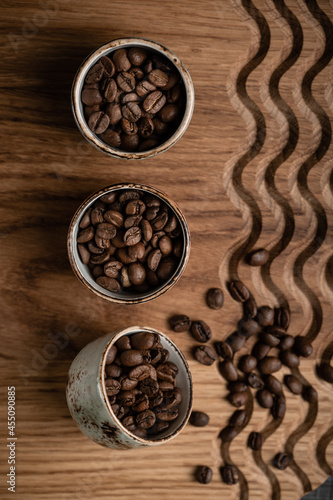coffee beans in cups on a wooden background with a pattern. High quality photo