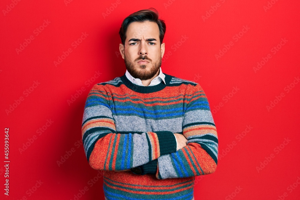 Handsome caucasian man with beard wearing elegant wool winter sweater skeptic and nervous, disapproving expression on face with crossed arms. negative person. Handsome caucasian man with beard wearing elegant wool winter sweater skeptic and nervous, disapproving expression on face with crossed arms. negative person.
