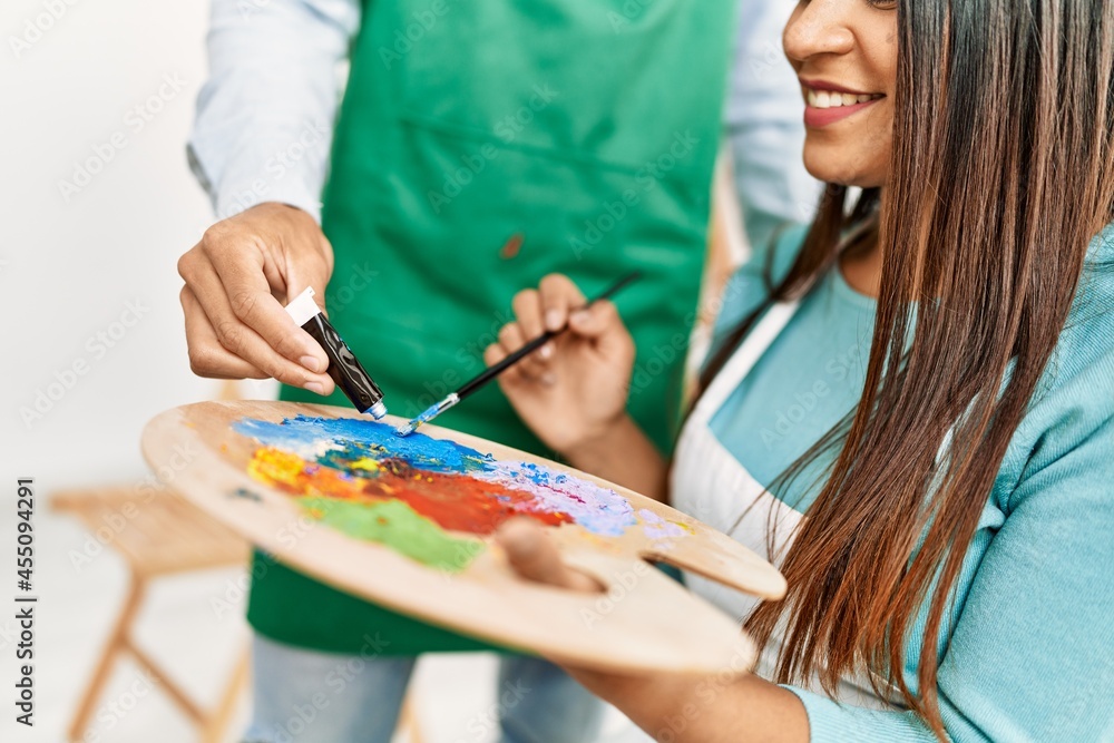Young latin painter couple smiling happy painting at art studio Young latin painter couple smiling happy painting at art studio
