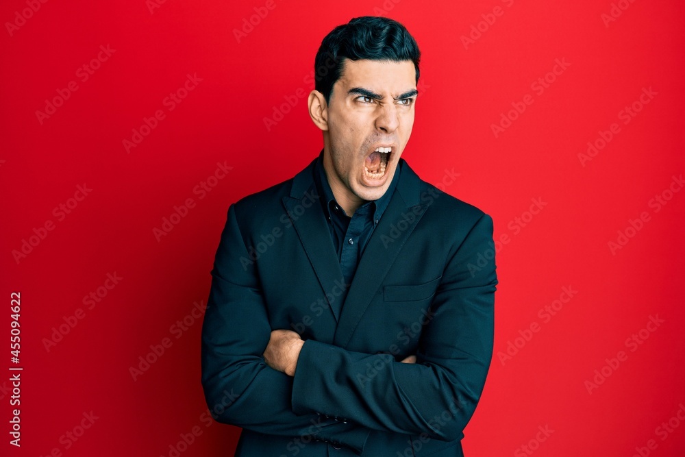 Handsome hispanic business man with arms crossed gesture angry and mad screaming frustrated and furious, shouting with anger. rage and aggressive concept. Handsome hispanic business man with arms crossed gesture angry and mad screaming frustrated and furious, shouting with anger. rage and aggressive concept.