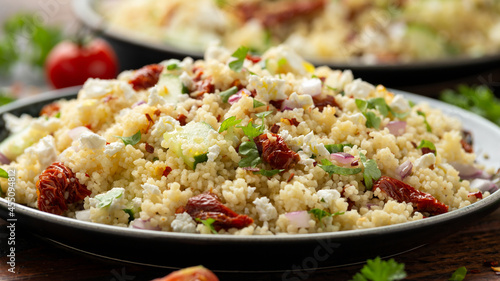 Couscous salad with sun dried tomatoes, cucumber, red onion and feta cheese. healthy food.