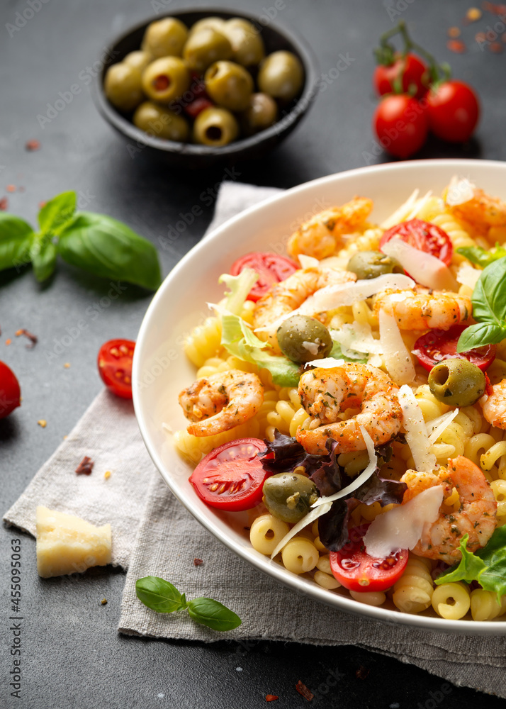 King prawn pasta salad with marinated green olives, cherry tomatoes and parmesan cheese shavings. Healthy food. King prawn pasta salad with marinated green olives, cherry tomatoes and parmesan cheese shavings. Healthy food.
