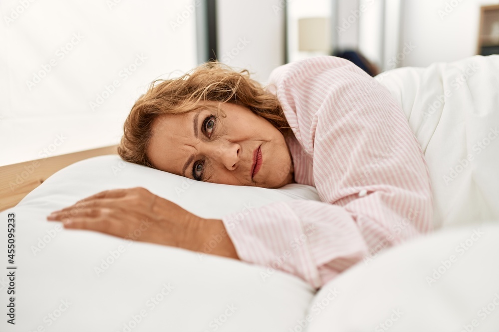 Middle age caucasian woman lying on the bed at bedroom. Middle age caucasian woman lying on the bed at bedroom.