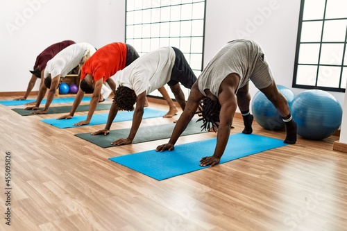 Group of young african american man training yoga at sport center.
