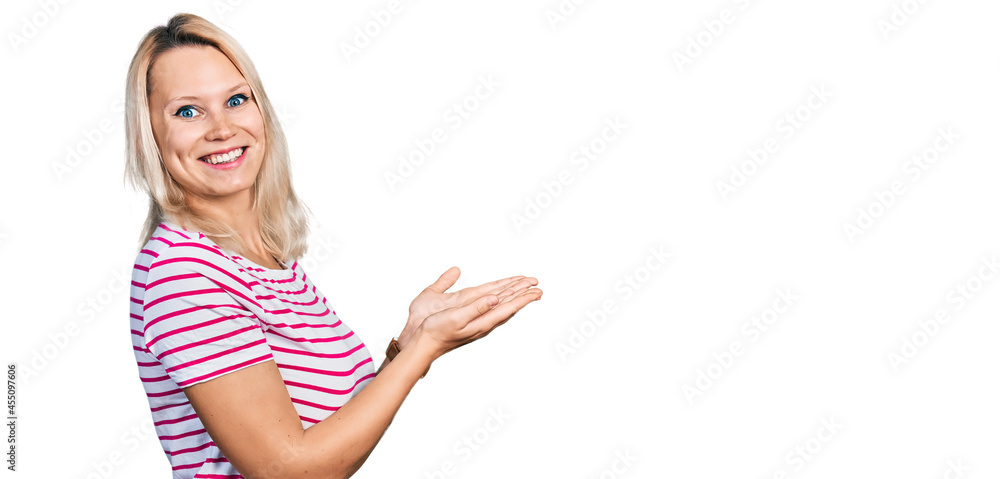 Young caucasian woman wearing casual clothes pointing aside with hands open palms showing copy space, presenting advertisement smiling excited happy Young caucasian woman wearing casual clothes pointing aside with hands open palms showing copy space, presenting advertisement smiling excited happy