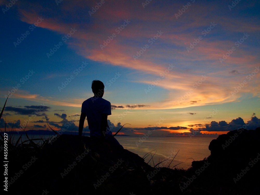 silhouette of a person at the sunset cliff and the ocean