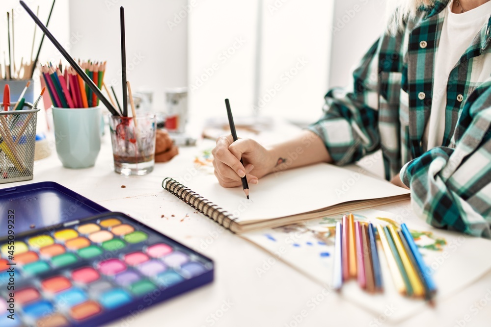 Artist student girl sitting on desk painting at art studio. Artist student girl sitting on desk painting at art studio.