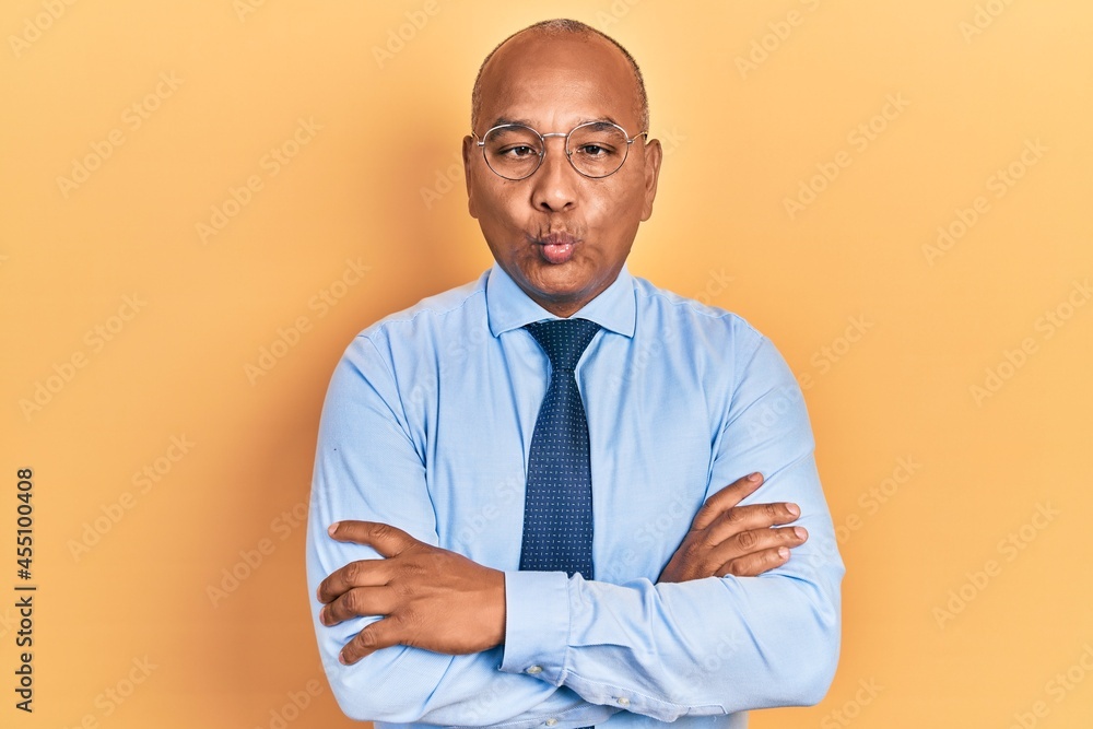 Middle age latin man wearing business clothes with arms crossed gesture making fish face with mouth and squinting eyes, crazy and comical. Middle age latin man wearing business clothes with arms crossed gesture making fish face with mouth and squinting eyes, crazy and comical.