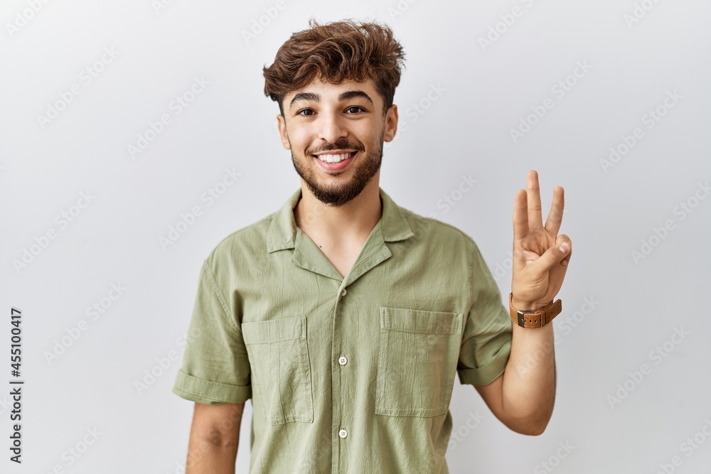 Young arab doctor man standing over isolated background showing and pointing up with fingers number three while smiling confident and happy. Young arab doctor man standing over isolated background showing and pointing up with fingers number three while smiling confident and happy.