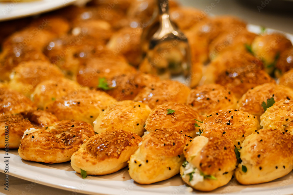 Closeup of fresh baked buns on tray. Stuffed buns served for breakfast on buffet line Closeup of fresh baked buns on tray. Stuffed buns served for breakfast on buffet line