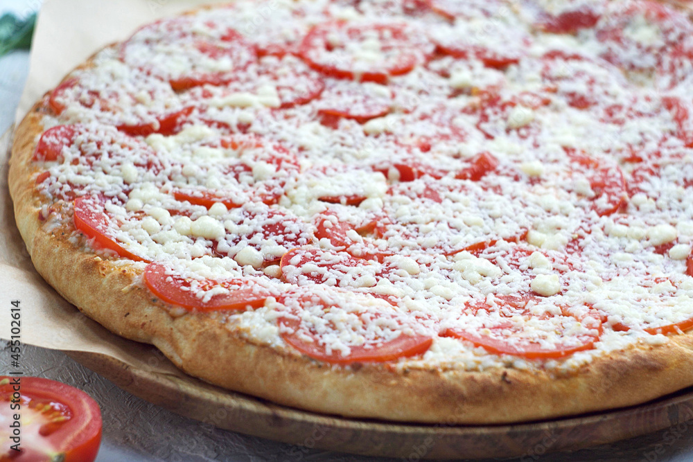 Pizza margarita with tomatoes and cheese on a wooden board. Pizza margarita with tomatoes and cheese on a wooden board.