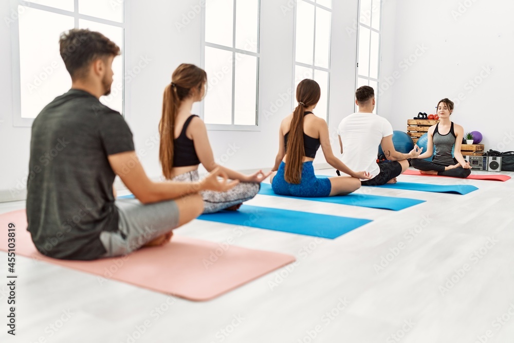 Group of young people having yoga class with personal trainer at sport center. Group of young people having yoga class with personal trainer at sport center.