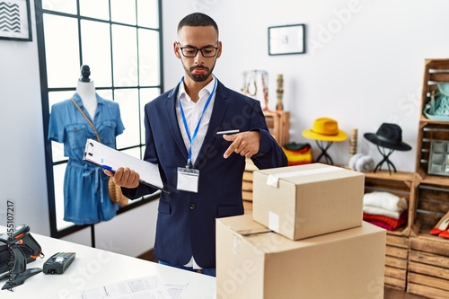 African american man working as manager at retail boutique pointing down looking sad and upset, indicating direction with fingers, unhappy and depressed. © Krakenimages.com