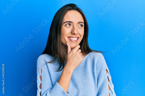 Young hispanic girl wearing casual clothes with hand on chin thinking about question, pensive expression. smiling with thoughtful face. doubt concept.
