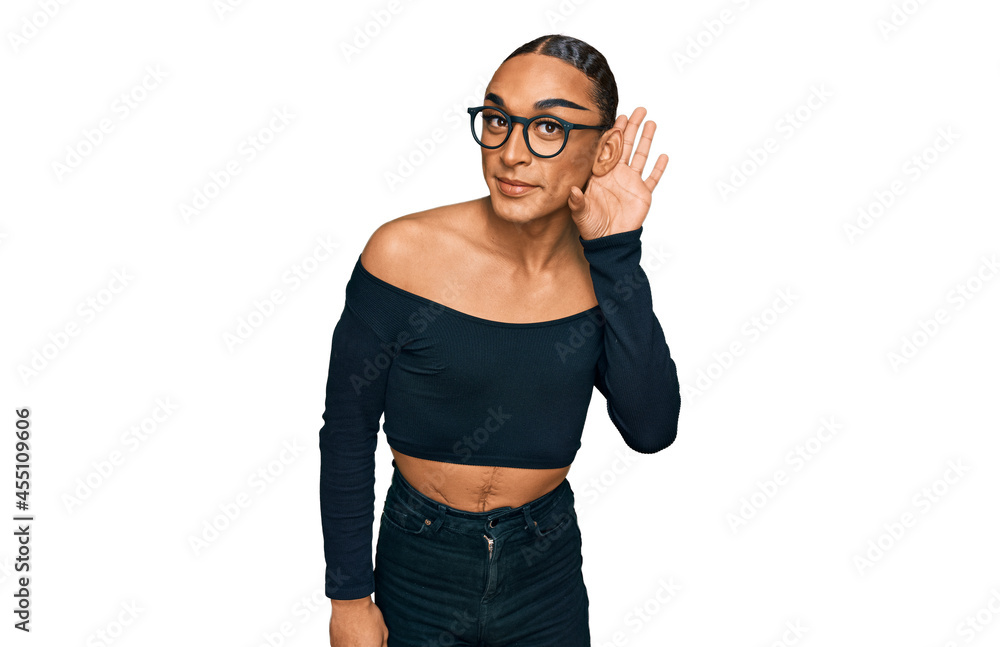 Fototapeta premium Hispanic transgender man wearing make up and long hair wearing women clothes smiling with hand over ear listening an hearing to rumor or gossip. deafness concept.