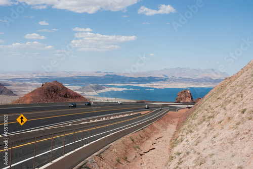 road in the desert with lake in background