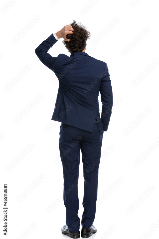 businessman scratching his head, holding one hand in pocket businessman scratching his head, holding one hand in pocket