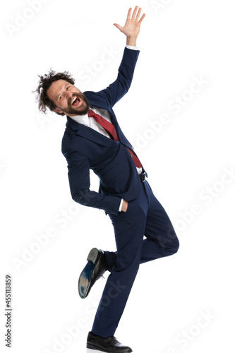 young businessman crossing his legs, raising his hand