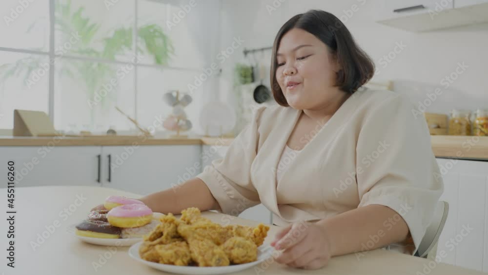 Asian young oversize big women feel happy for unhealthy foods on plate Asian young oversize big women feel happy for unhealthy foods on plate