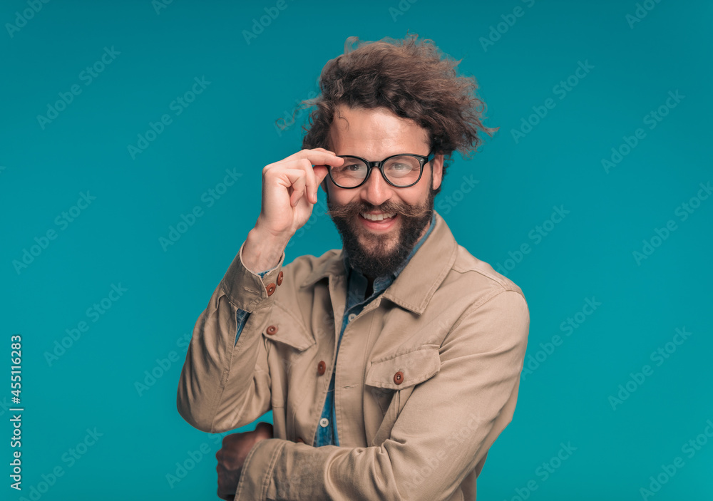 handsome young man crossing arms and adjusting eyeglasses handsome young man crossing arms and adjusting eyeglasses