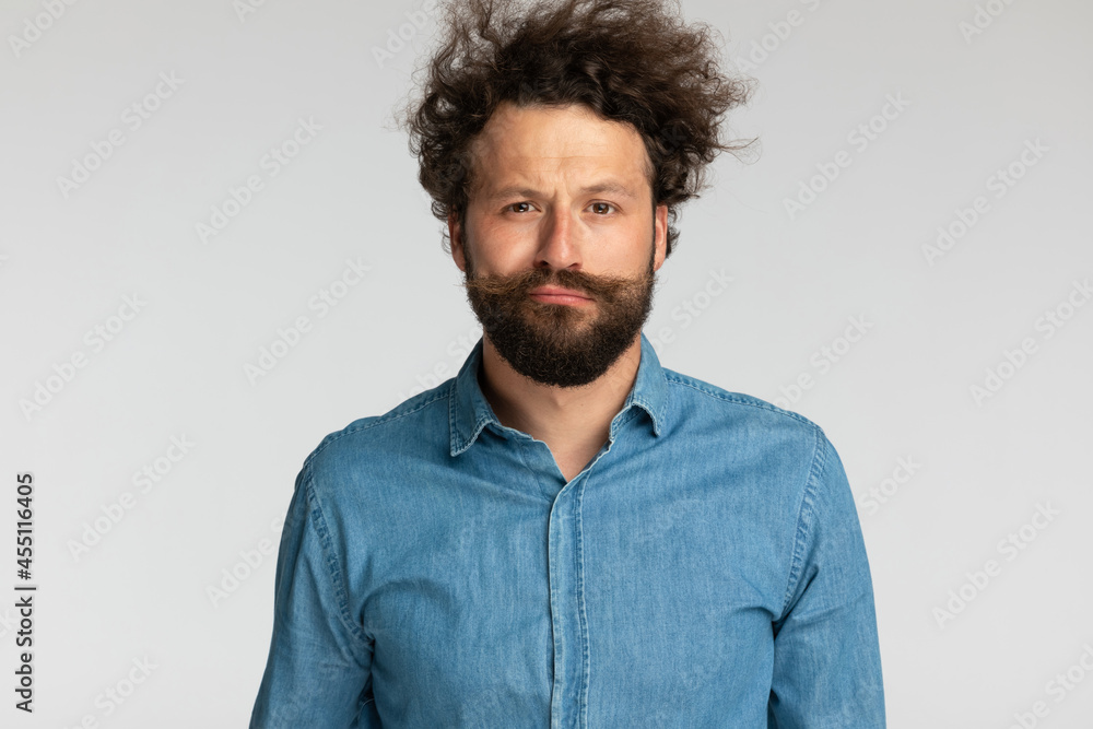 portrait of handsome man in denim shirt with curly hair posing portrait of handsome man in denim shirt with curly hair posing
