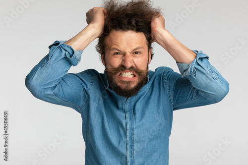 angry bearded man being nervous and pulling hair out