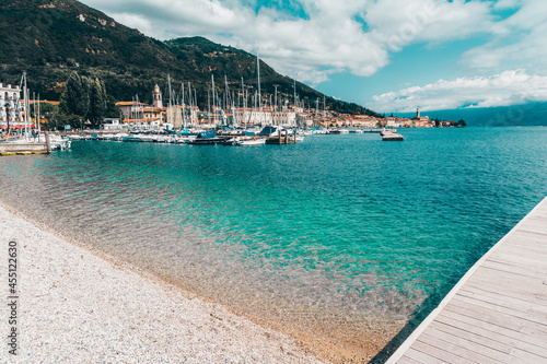 View of Lake Garda in summer with restaurants near the lake, small town of Salò, Italy