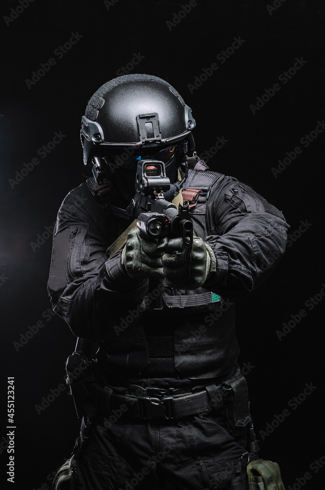 Military man in combat gear with weapons on a black background. Military man in combat gear with weapons on a black background.