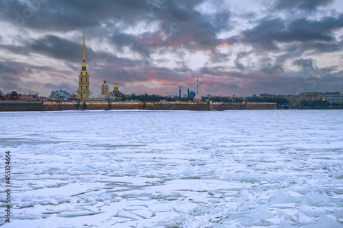 Saint-Petersburg in winter. Ice on the Neva River on the background of the Peter and Paul Fortress. Petersburg rivers. Russian cities in winter. Peter and Paul Fortress and cracked ice on Neva River. © Grispb