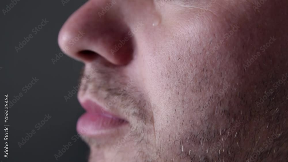Young man crying with a tear running down his cheek. Pain and suffering concept