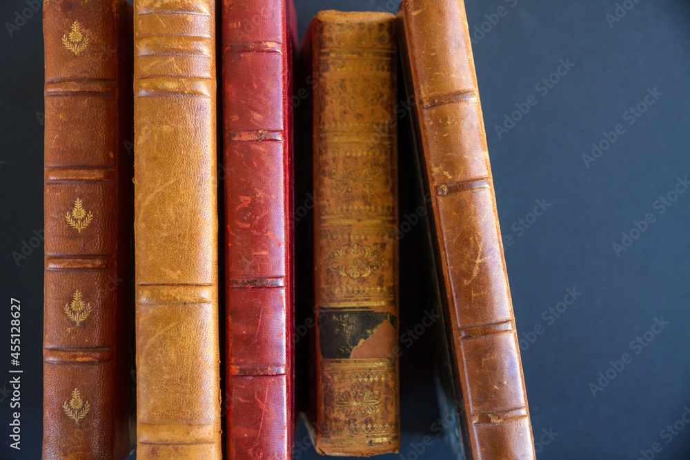 Row of old books on dark background Row of old books on dark background