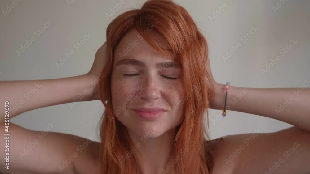 Attractive young girl with red hair covers her ears with her hands. Attractive young girl with red hair covers her ears with her hands.