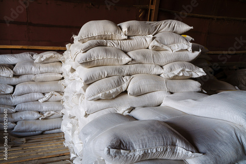 Large cloth bags with unknown bulk contents are lying in the warehouse. An image illustrating the products confiscated due to sanctions, or the capture of smugglers with illegal goods. photo