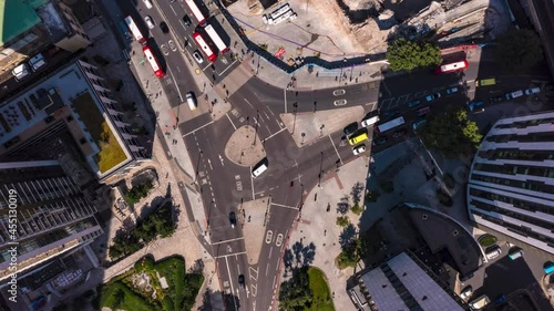 Aerial birds eye overhead top down descending hyperlapse footage of traffic on road intersection between Elephant and Stata tall buildings in sunny afternoon. London, UK photo