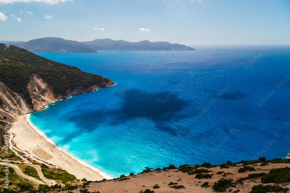 A top view at Myrtos Beach and fantastic turquoise and blue Ionian Sea water. Aerial view, summer scenery of famous and extremely popular travel destination in Cephalonia, Greece, Europe