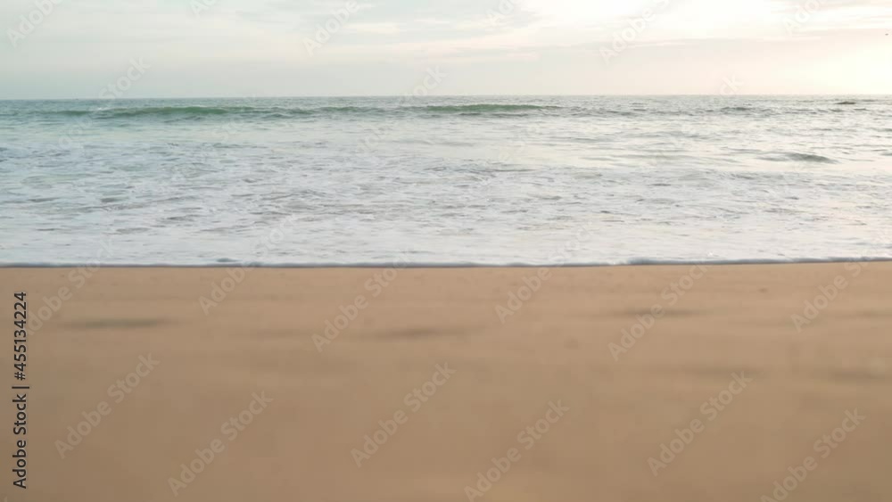 Sandy beach landscape at sunset. Waves on the sea. Lighthouse Sandy beach landscape at sunset. Waves on the sea. Lighthouse