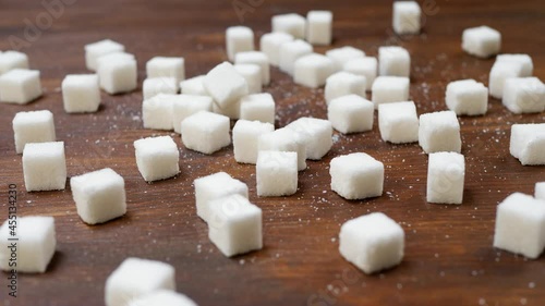 white sugar cubes on wooden brown background