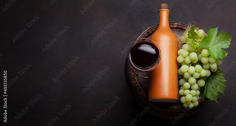 Obraz premium Wine bottle and glass on old barrel