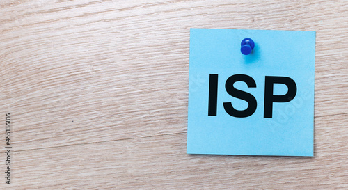 On a light wooden background - a light blue square sticker with the text ISP Internet Service Provider