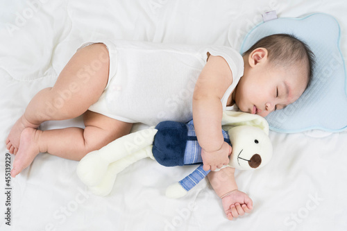Selective focus portrait of a sleeping Charming baby Cute newborn sleeps with a toy teddy bear on comfortable bed