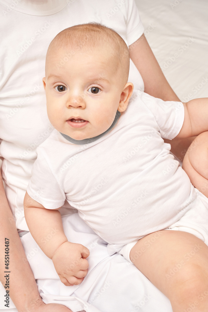 Cute small boy at house. Childhood concept. Light background. Smiling child. Happy emotion. Copyspace. Stay home. Onesie mockup. White clothes. Lying in mom Cute small boy at house. Childhood concept. Light background. Smiling child. Happy emotion. Copyspace. Stay home. Onesie mockup. White clothes. Lying in mom