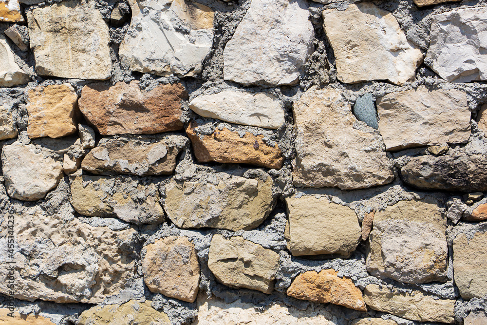 Obraz premium The rough textured surface of the wild stone wall. Background.