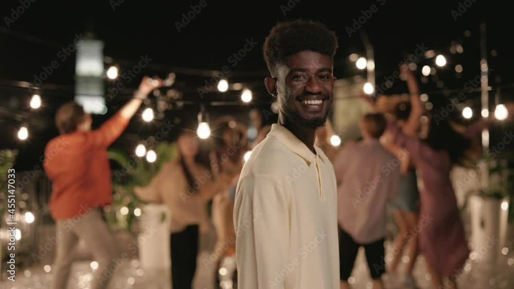 Smiling african man posing on camera during rooftop party Smiling african man posing on camera during rooftop party