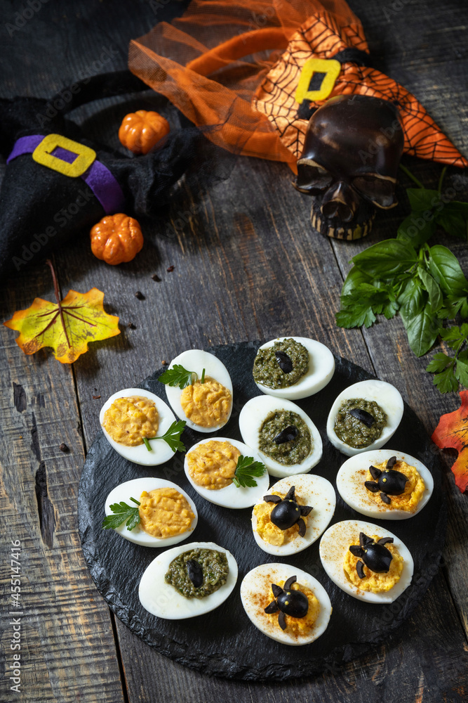Halloween funny idea for party food. Halloween creative set stuffed eggs on a wooden table.