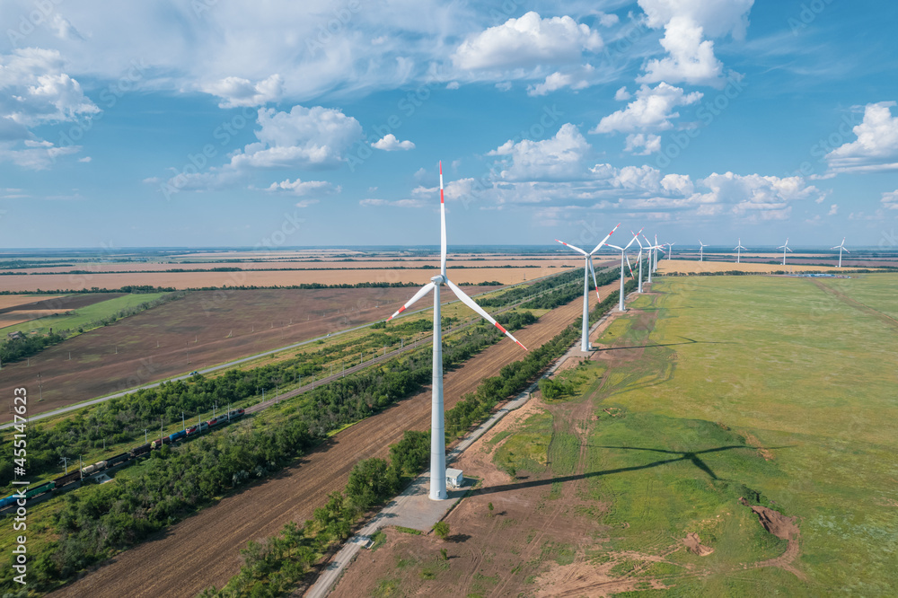 Aerial view of Wind power turbine is a popular sustainable, renewable energy source on beautiful cloudy sky. Wind power turbines generating clean renewable energy for sustainable development.